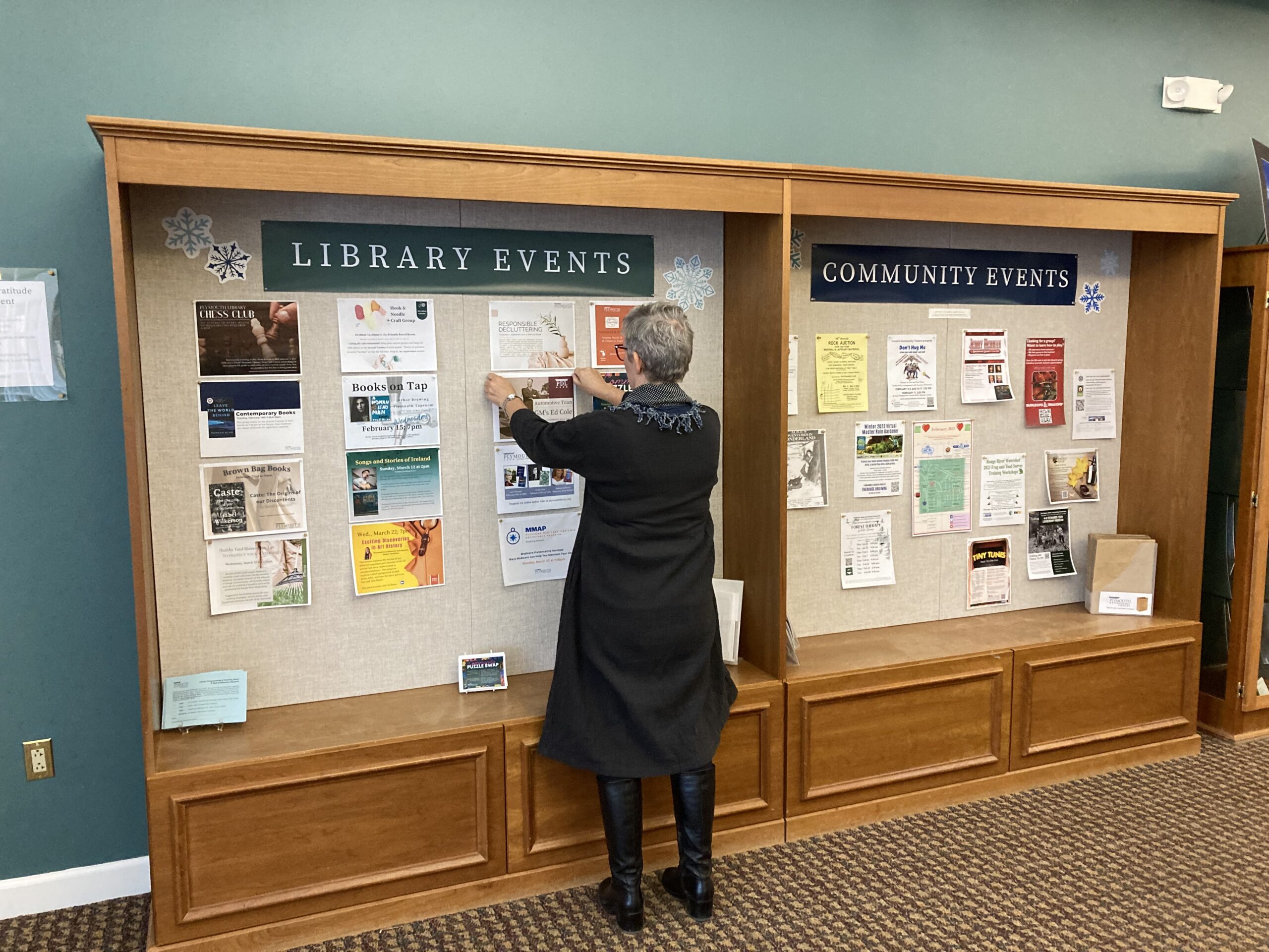 Librarian posts flyer to notice board