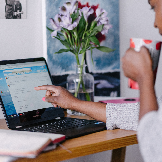 a woman uses a chromebook on a table in her home