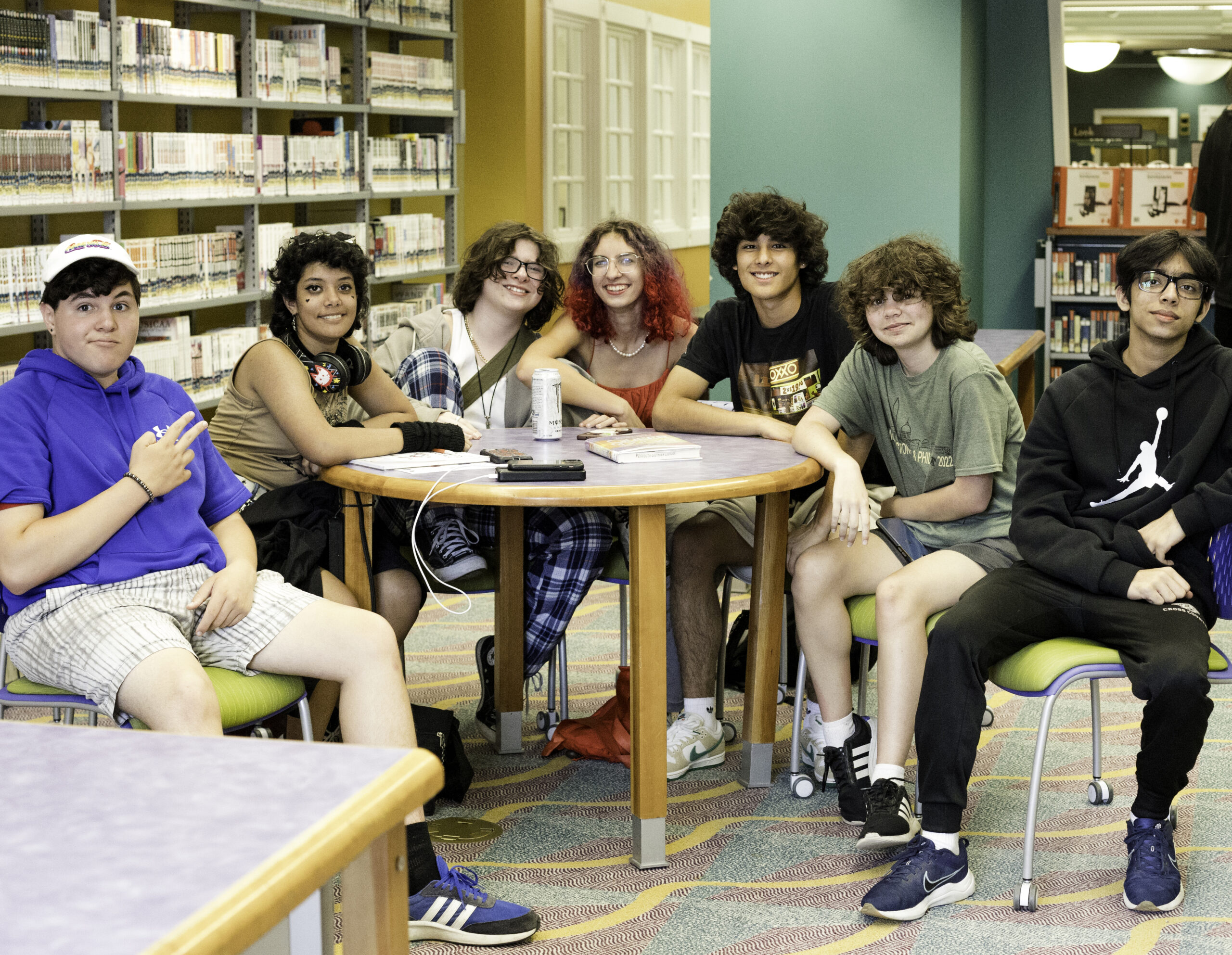 teens gather around a library table