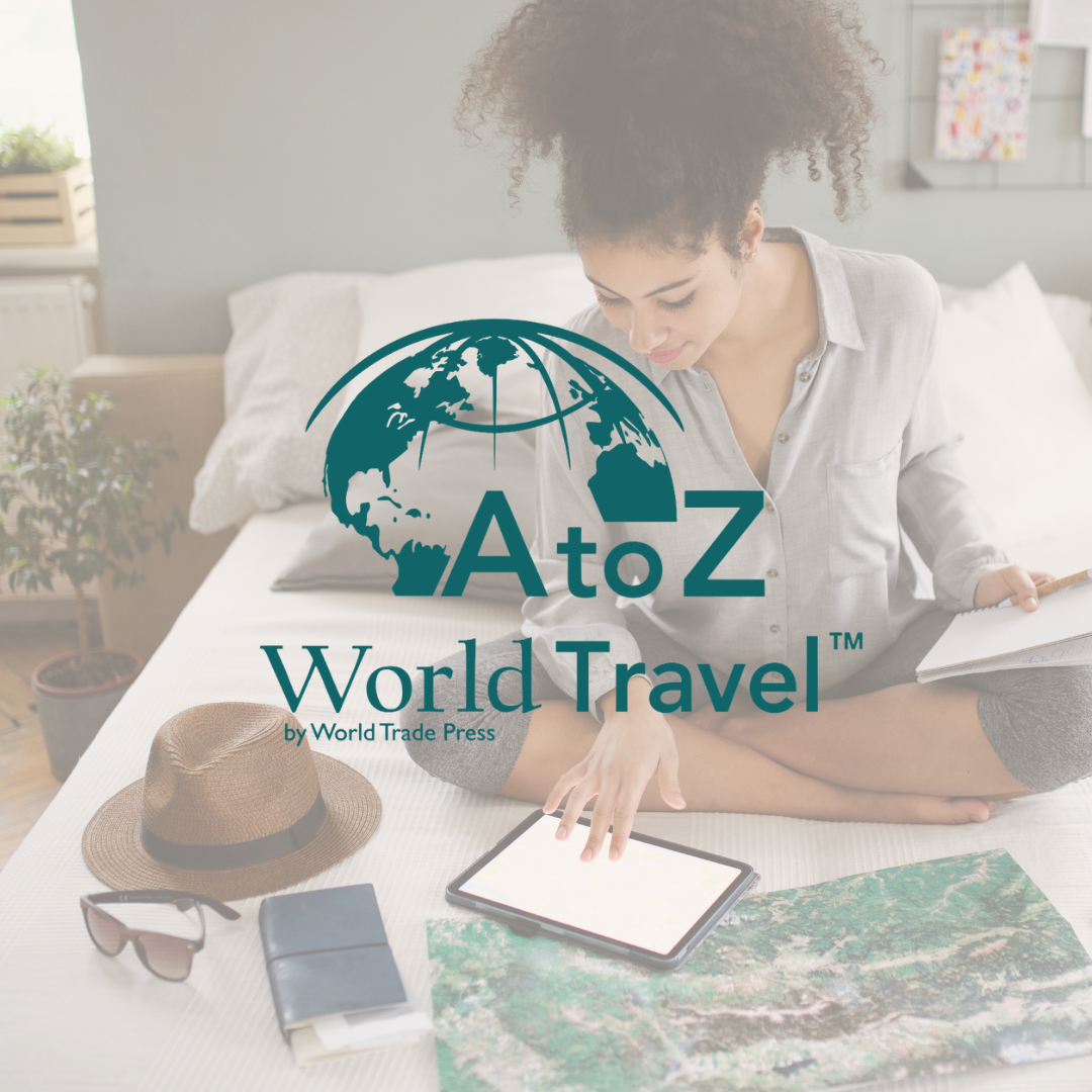 woman sits on bed planning a trip with map, passport and touchscreen tablet
