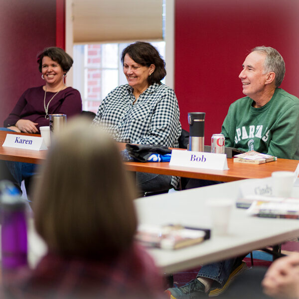 adult members of book club talk and laugh