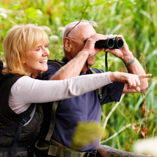 senior couple in nature with binoculars