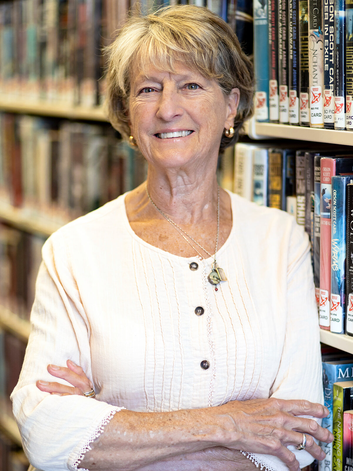 woman standing in front of books smiling