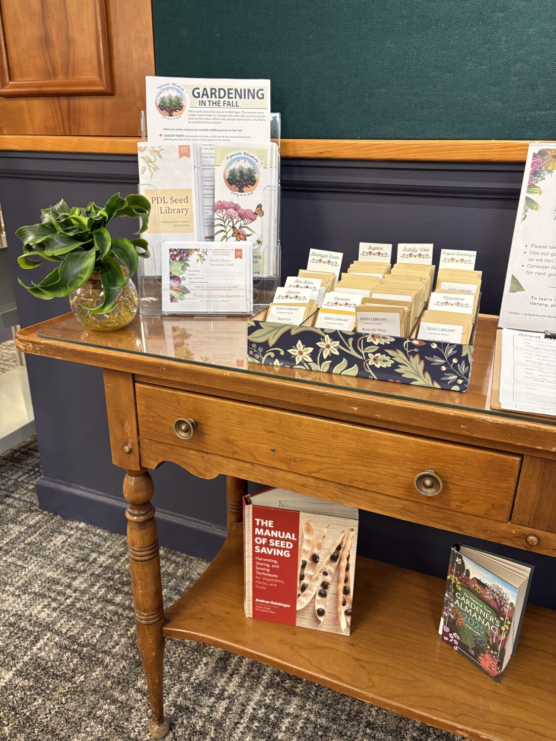 A wooden desk located on the Upper Level of the library that holds a drawer filled with seed packets.