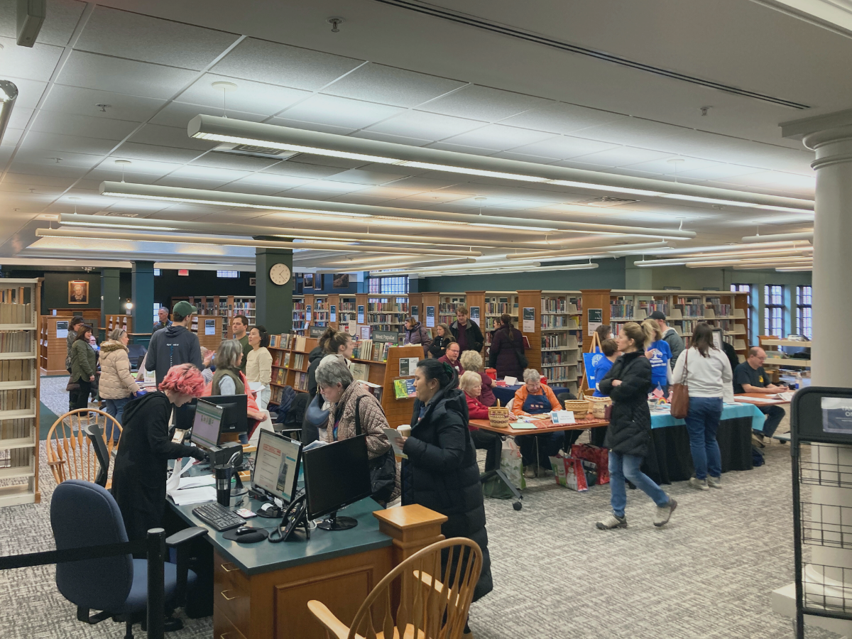 Event attendees speak with community members at various tables about events in the Plymouth area inside the Plymouth District Library.