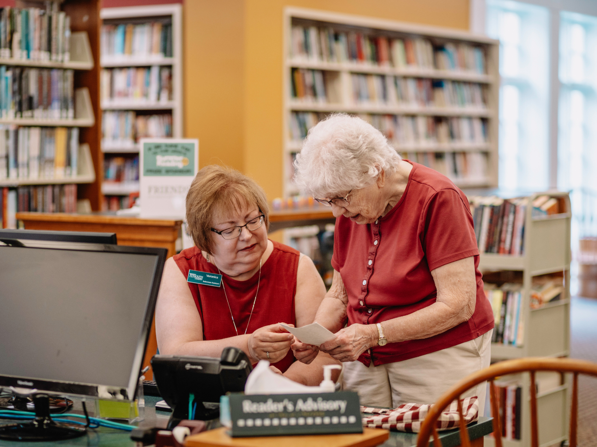 Reference Assistant Veronica assists a patron at the library's Readers' Advisory desk.