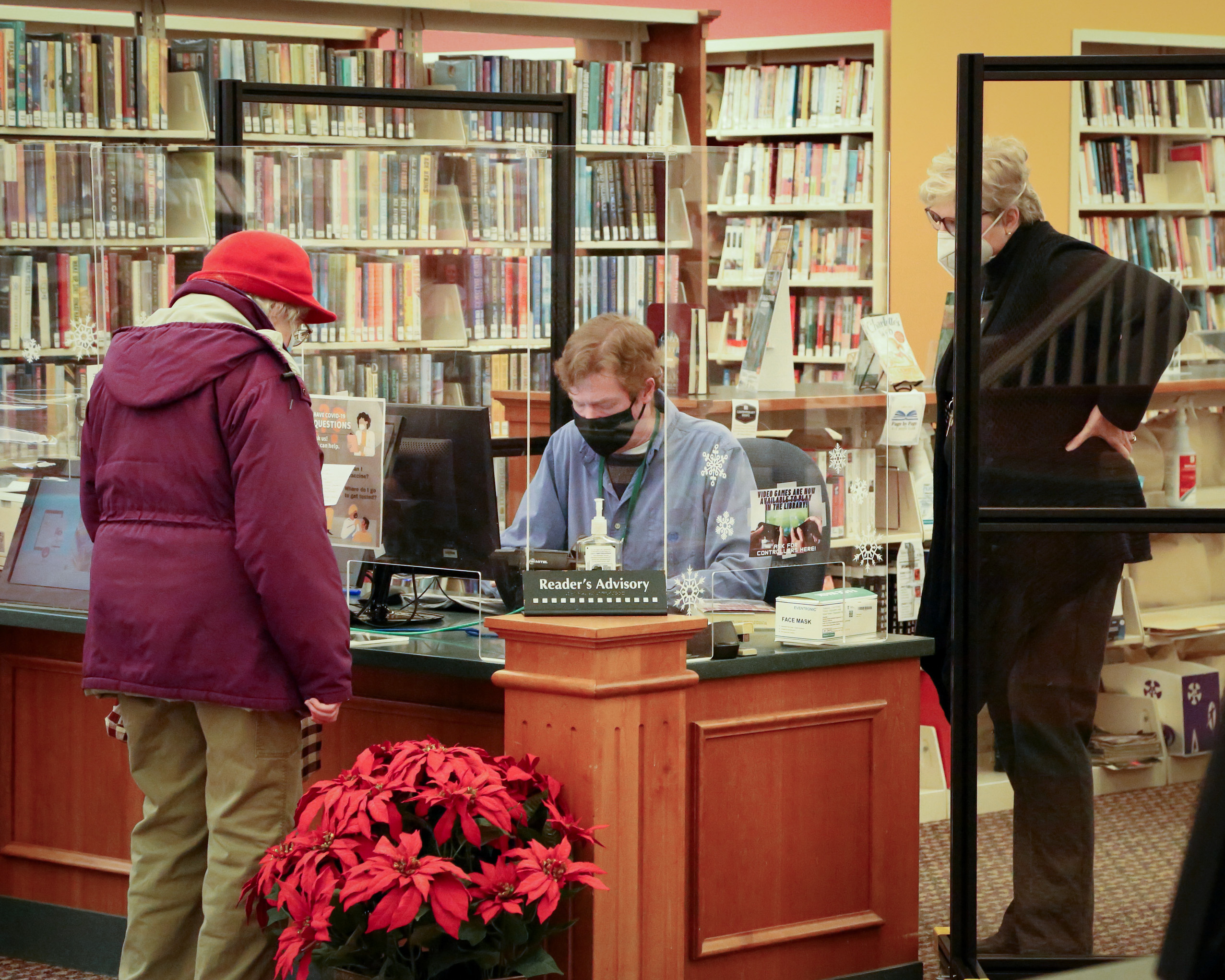 people talking at the library information desk